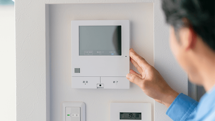 インターホンと男性の画像