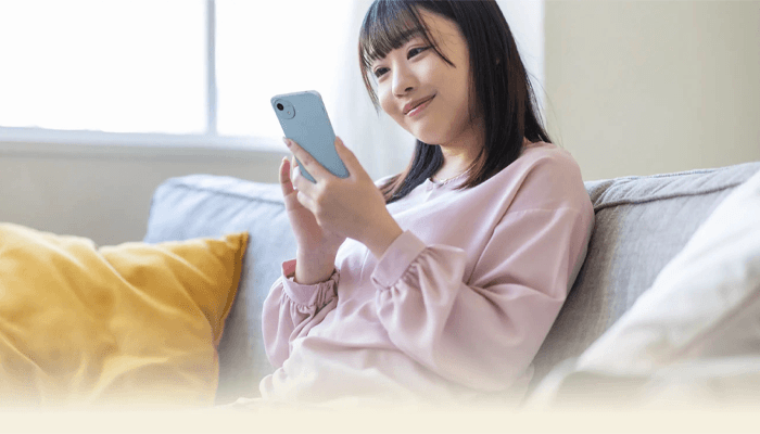 シャープ公式よりAQUOS wish4を操作している女性の画像